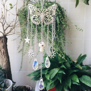 Detail of silver butterfly suncatcher featuring crystal prisms and metal pendants