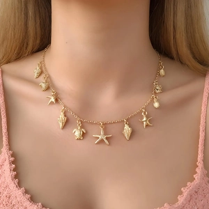 Golden ocean theme necklace with shell and starfish pendants on model's neck