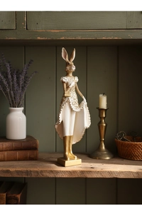 Elegant white resin rabbit figurine in gold dress on a vintage green wooden cabinet