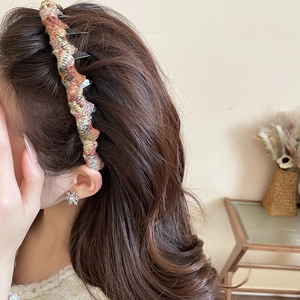Detail shot of a knitted wavy headband showing colorful acrylic yarn texture and cozy style