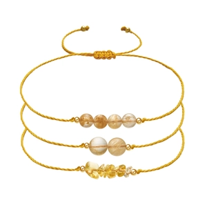 Detail of three handmade braided gold ropes with citrine beads and adjustable pull cords