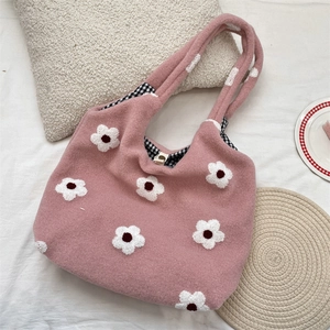 Detail view of pink plush tote with white flower embroidery and checkered lining