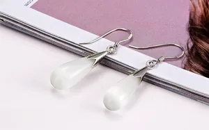 Close-up of minimalist cat eye stone drop earrings with elegant silver hooks