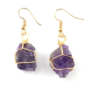 Detail of handmade gold wire-wrapped raw purple amethyst stone drop earrings