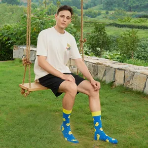 Blue crew socks with yellow duck pattern and ribbed cuffs shown in a nature setting