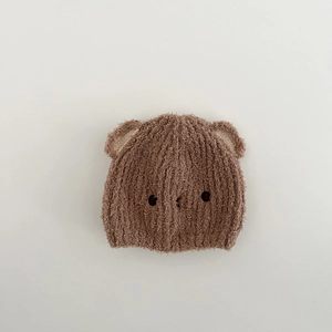 Nahaufnahme der niedlichen braunen Plüsch-Babymütze im Bären-Design für den Winter