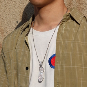 Macro shot of silver hip-hop scooter pendant with sparkling diamonds and twist chain
