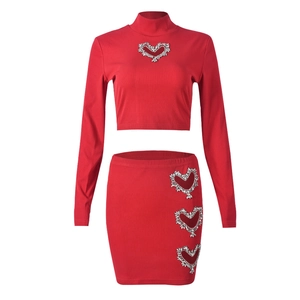 Macro shot of rhinestone heart cutouts on a red ribbed knit two-piece crop top set