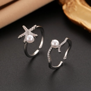 Détail de la bague étoile de mer argentée avec perles blanches et zircons sur fond noir