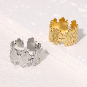 Primer plano detallado de anillos de hoja en oro y plata con texturas de vetas finas