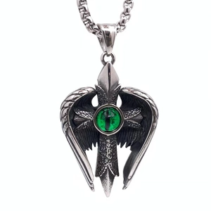 Macro shot of titanium steel angel wing cross pendant with green eye design