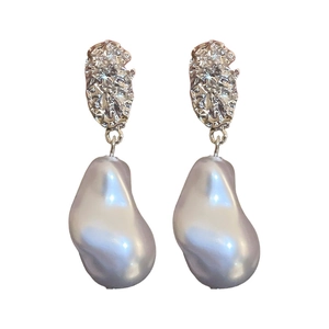 Irregular textured silver drop earrings with large baroque pearls on a white background