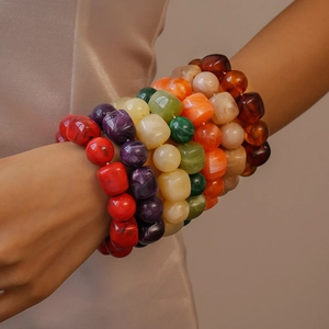 Detail of colorful acrylic beads bracelet with marble texture worn on a model's wrist