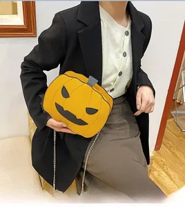 Detail of pumpkin-shaped crossbody bag with golden chain strap and sequin finish