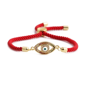 Adjustable red rope bracelet with a gold evil eye pendant and colorful zircon stones
