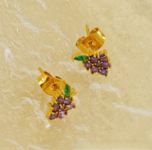 Close-up of 18K gold plated grape stud earrings with purple zircons and green leaf detail