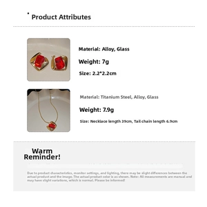 Close-up of gold geometric necklace and earrings set featuring rectangular red glass stones
