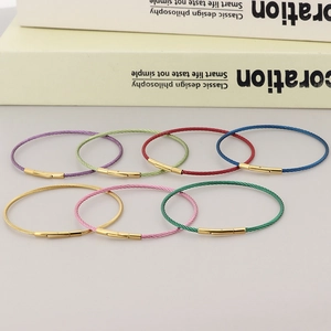 Detail of colorful 2mm stainless steel wire bracelets with golden screw clasps
