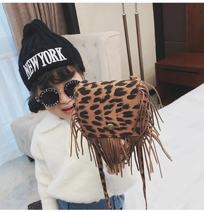 Girl wearing a leopard print crossbody bag with fringe detail and a round sunglasses