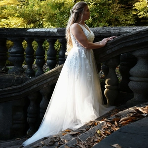 Detailed side view of white lace floral embroidery on an elegant A-line tulle wedding gown