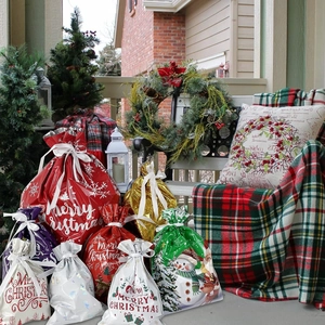 Variety of Christmas drawstring gift bags in a festive outdoor holiday setting