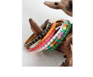 Macro shot of colorful enamel bangles with gold trim hanging on a natural wooden branch