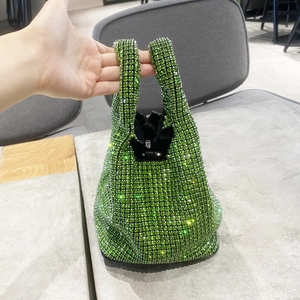 Close-up of green rhinestone bucket bag featuring a sparkling mesh crystal surface