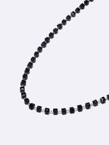 Detail of black faceted crystal beads with golden metal rings for sunglasses chain