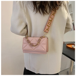 Detail of pink quilted square bag with patterned wide strap and resin chain link