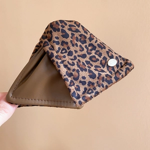 Detail of leopard print fabric hair claw with brown leather lining and silver metal stud