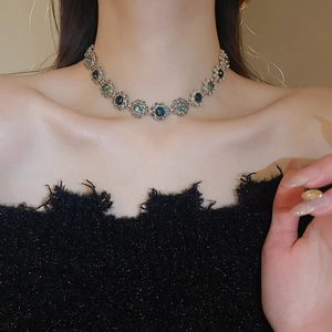 Close-up of vintage flower choker with blue gems on a female model with soft lighting