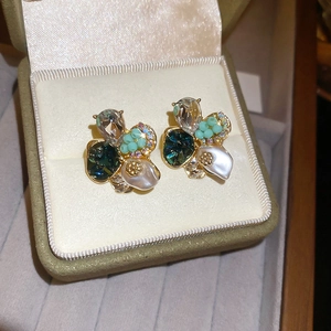 Gros plan détaillé de boucles d'oreilles florales avec cristaux bleus et perles en écrin