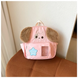 Detail view of pink canvas backpack with plush ears and blue star patch on soft fabric