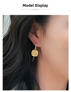 Detailed close-up of a vintage matte gold sunflower earring worn by a female model