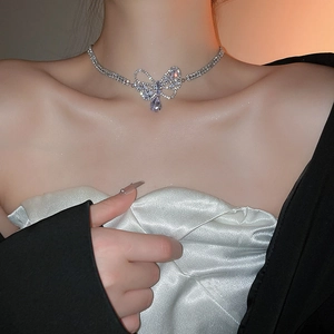 Model wearing a silver bow necklace with a sparkling zircon water drop pendant