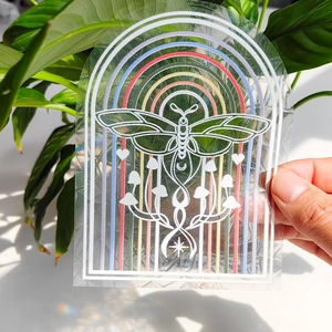 Detailed close-up of arched suncatcher sticker with rainbow, insect, and mushroom patterns