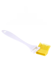 Close-up of detachable silicone brush head and white handle for easy kitchen cleaning