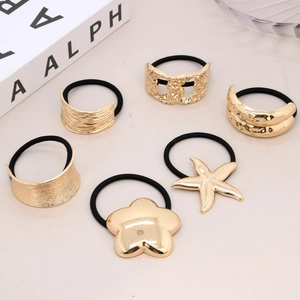 Set of 6 black elastic hair ties featuring diverse gold metal charms with star and flower motifs