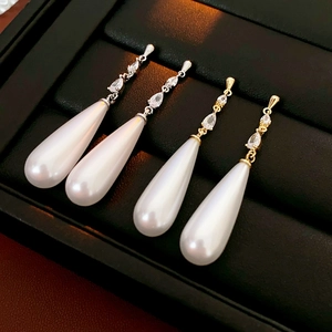 Detailed view of 14k gold plated drop fringe earrings with zircon and pearls