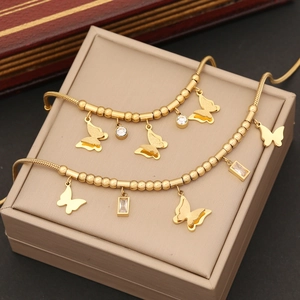 Elegant gold butterfly pendant necklace with embedded gemstones on a display box