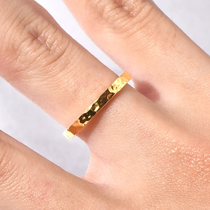 Detailed view of irregular hammered texture on 18K gold plated titanium ring