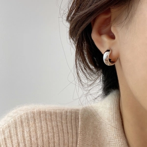 Close-up of minimalist silver hoop earring with high-polish finish on model