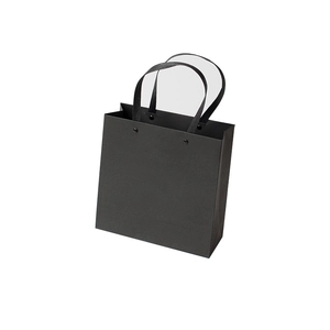 Minimalist black paper gift bag with rivet handles shown from a front-facing perspective