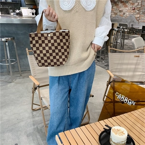 Detail of corduroy checkerboard tote bag showing secure snap button and fabric texture