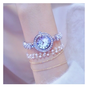 Macro shot of a silver luxury women's quartz watch featuring crystal-set bezels and links