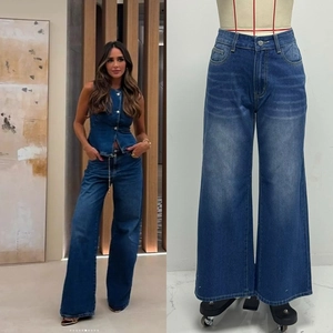 Detail view of high-waist wide-leg denim trousers in deep blue washed finish