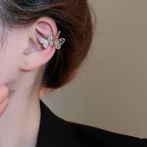 Detail of silver C-shaped ear cuff featuring sparkling cubic zirconia butterfly design