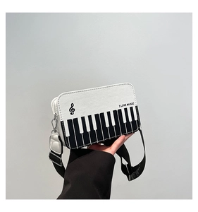 Detail of music theme crossbody bag with piano key pattern and I LOVE MUSIC text