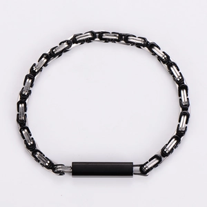 Detail of silver stainless steel Byzantine chain with black ring accents and matte plaque