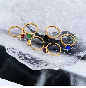 Detailed view of six colorful natural stone rings with 18K gold plated finish